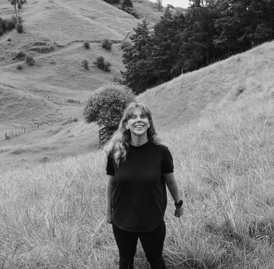 Daisy standing in tall grass on the New Zealand hills, smiling
